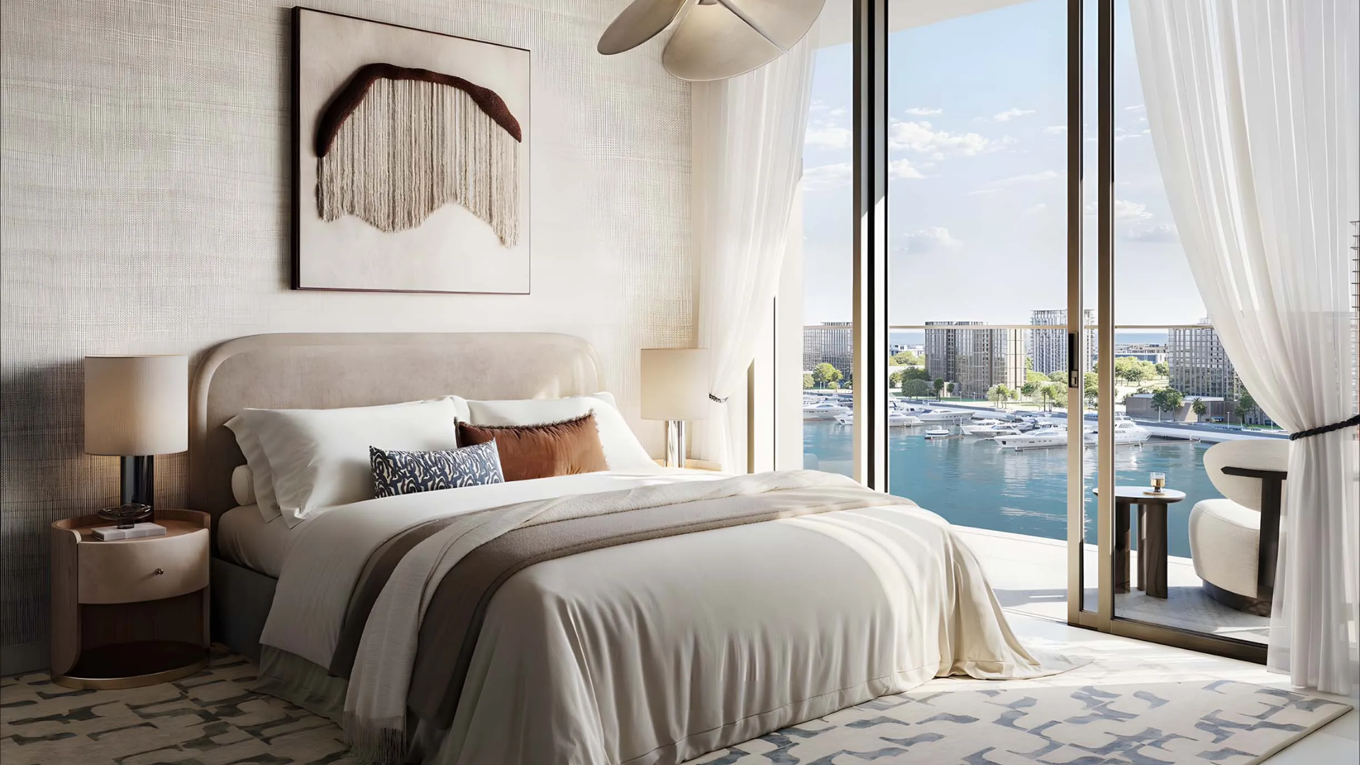 Modern bedroom with balcony overlooking a waterfront filled with yachts.