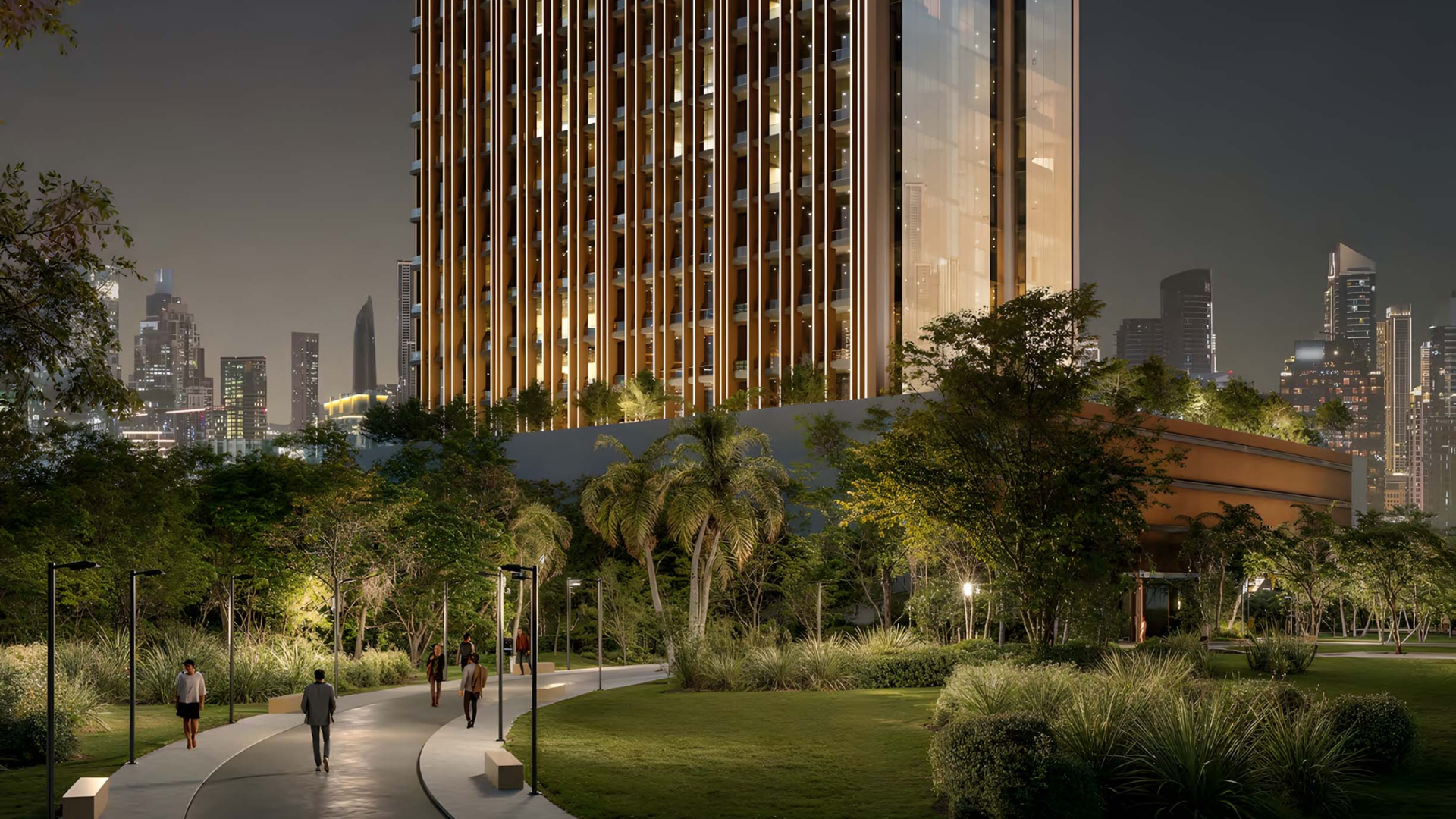 High-rise tower with people walking along landscaped urban paths at dusk