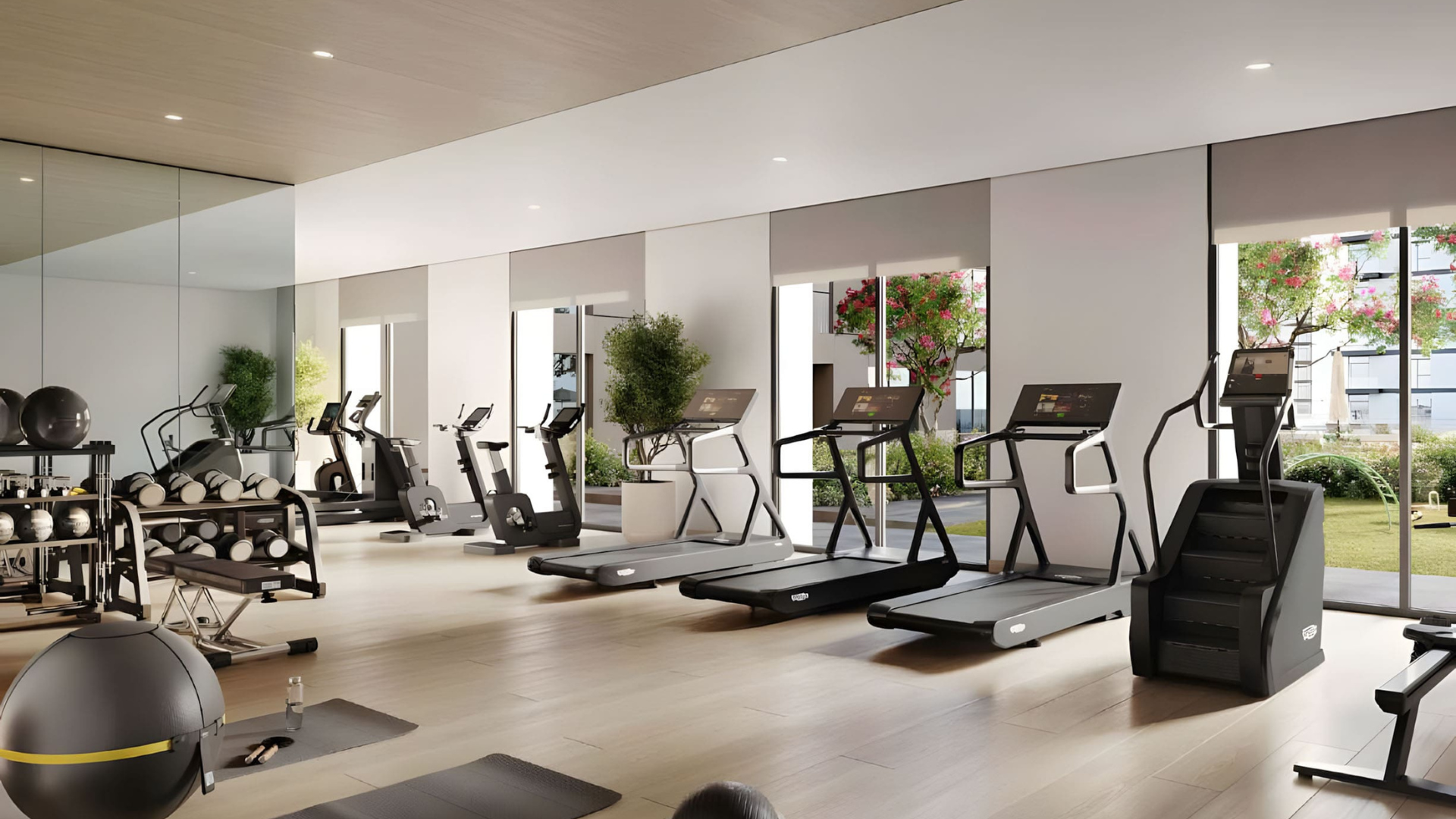 Bright fitness center featuring large windows and garden views