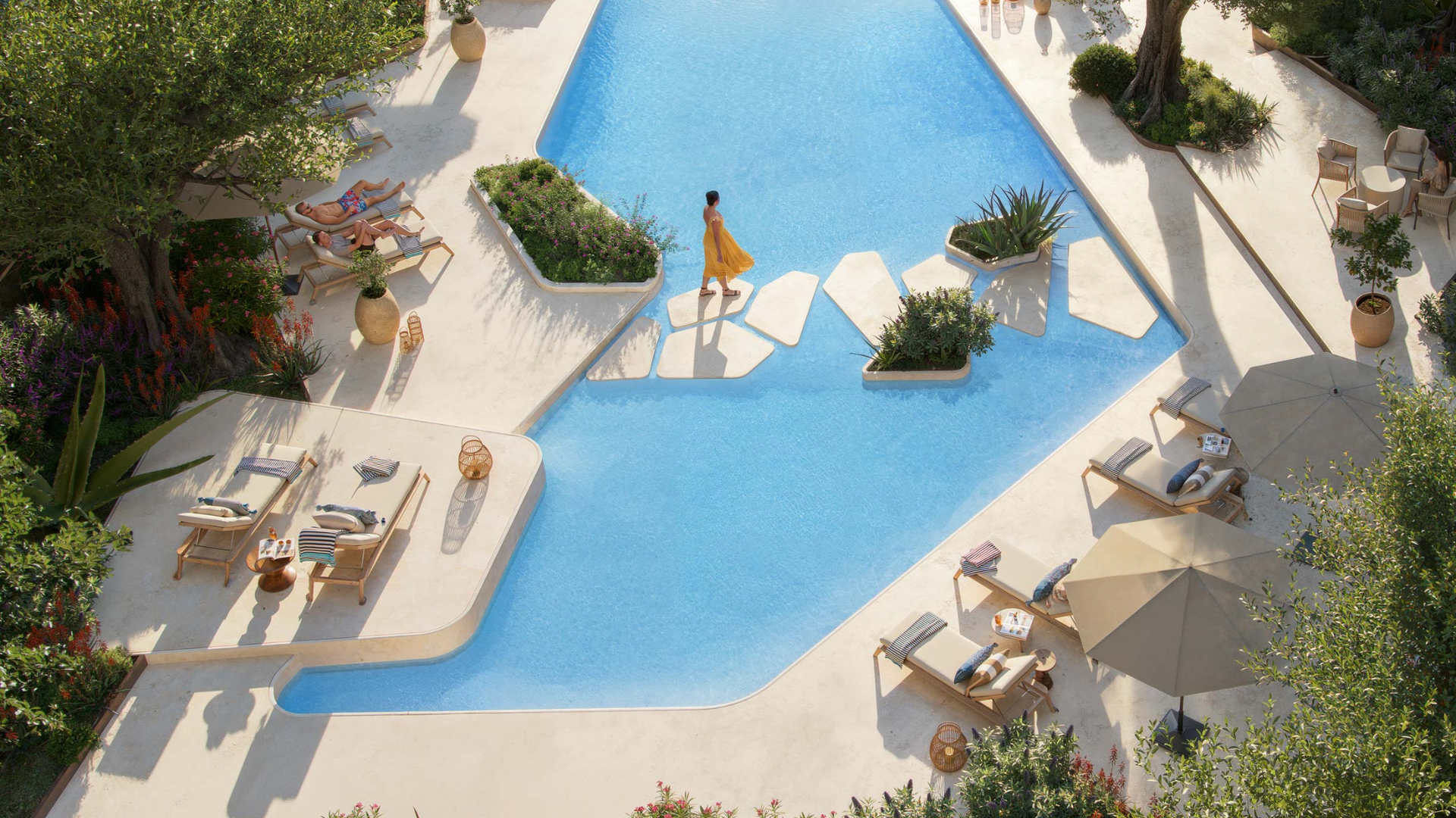 Luxury swimming pool with sunbeds and greenery