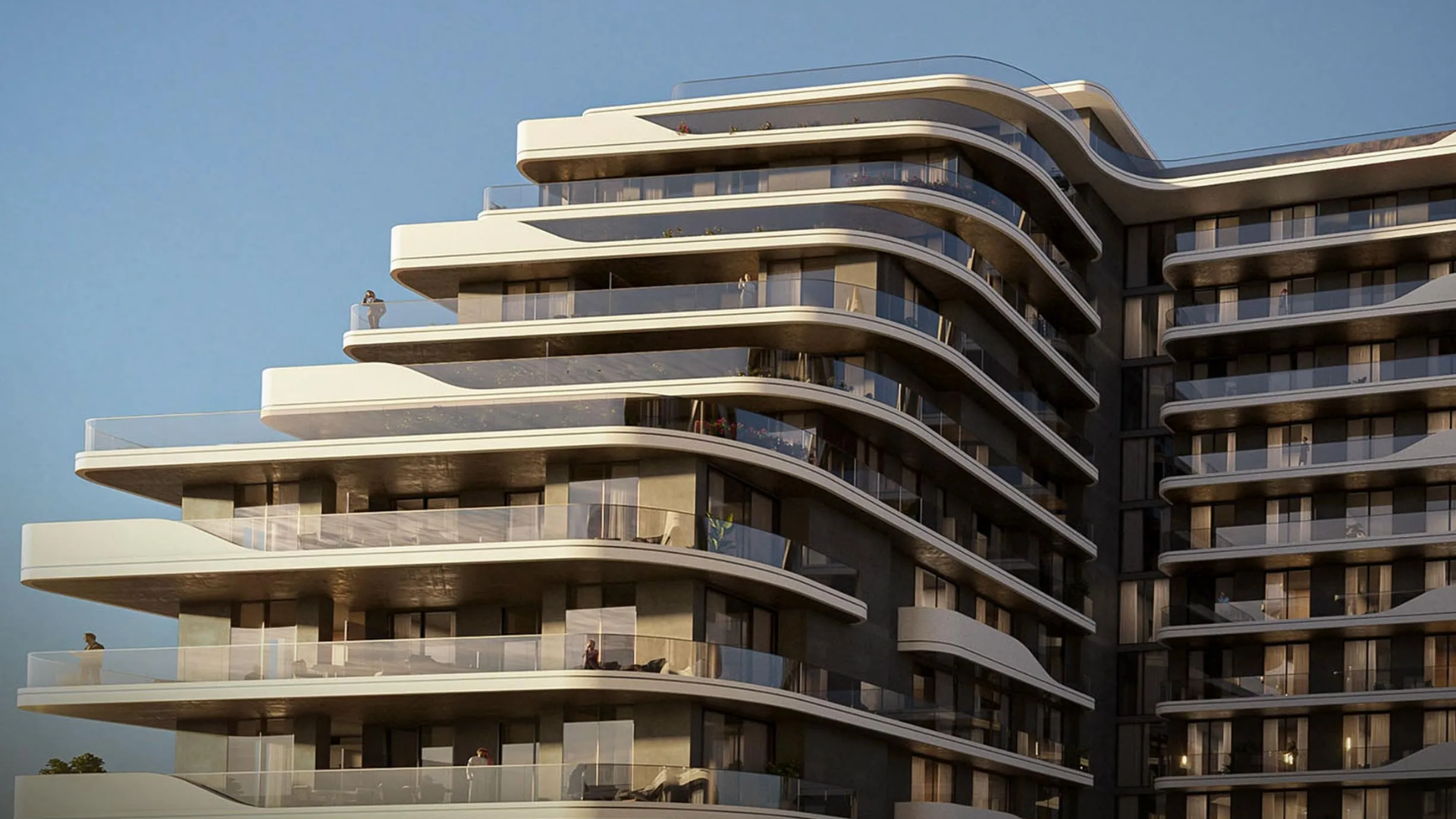 A close-up view of a modern residential building with a curved, flowing facade and expansive balconies with glass railings.