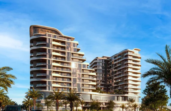 A modern residential building with a curved, layered facade, surrounded by palm trees under a clear sky.