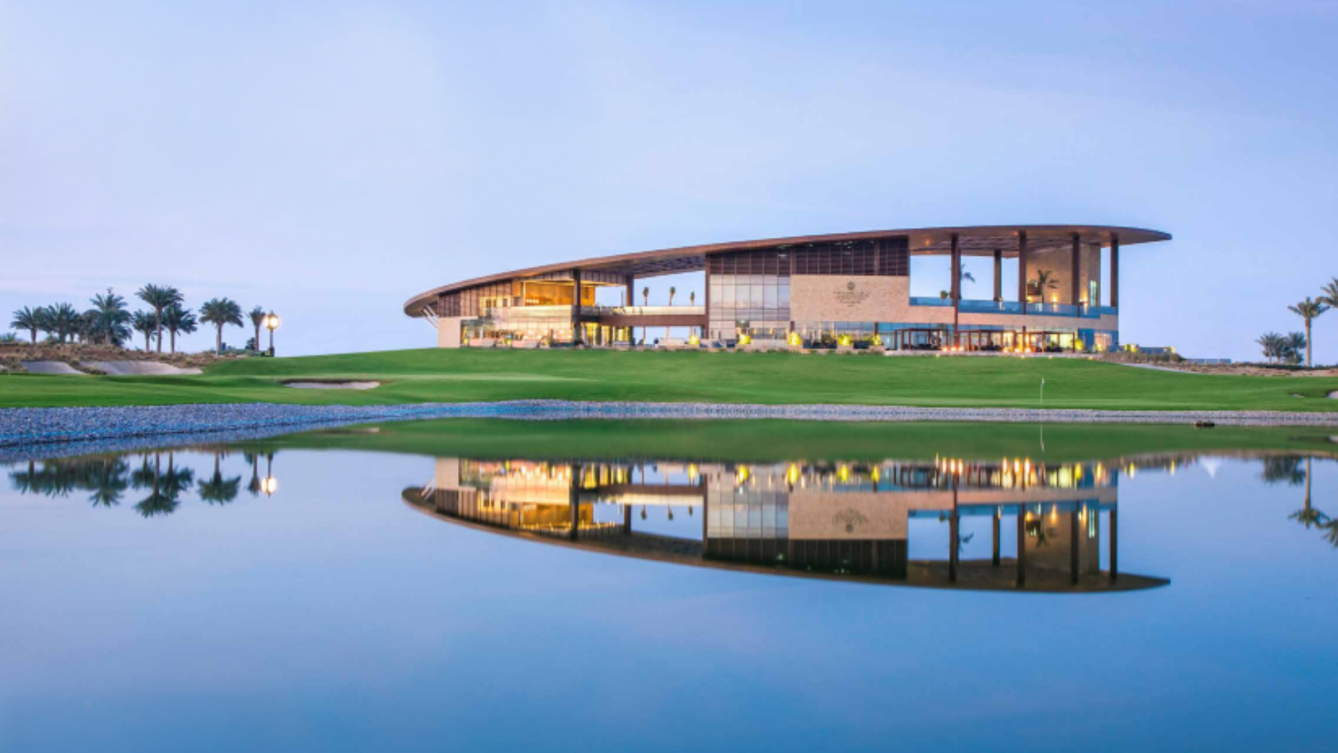 Golf course view near Golf Greens Tower 2 with modern clubhouse and water reflection