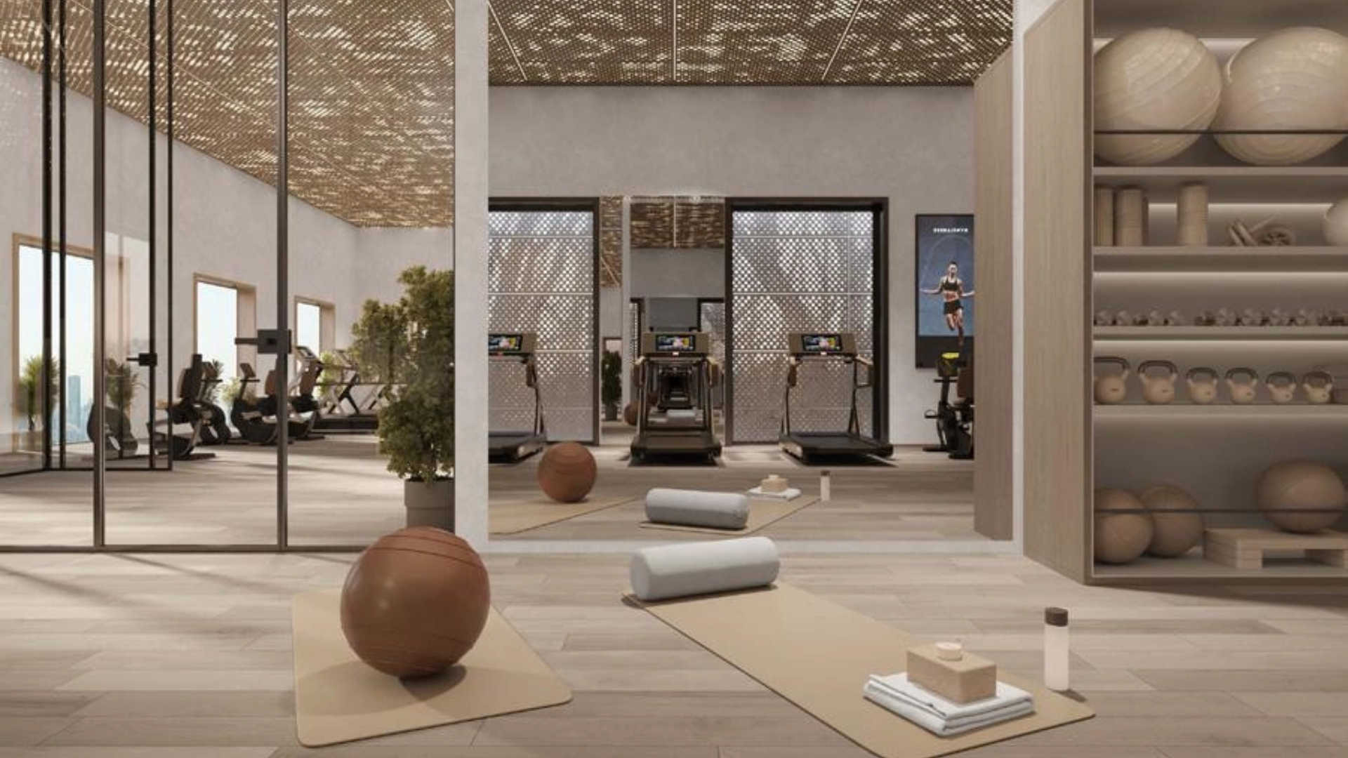 Modern fitness studio at AHS Luxury Office Tower with exercise equipment and yoga mats.