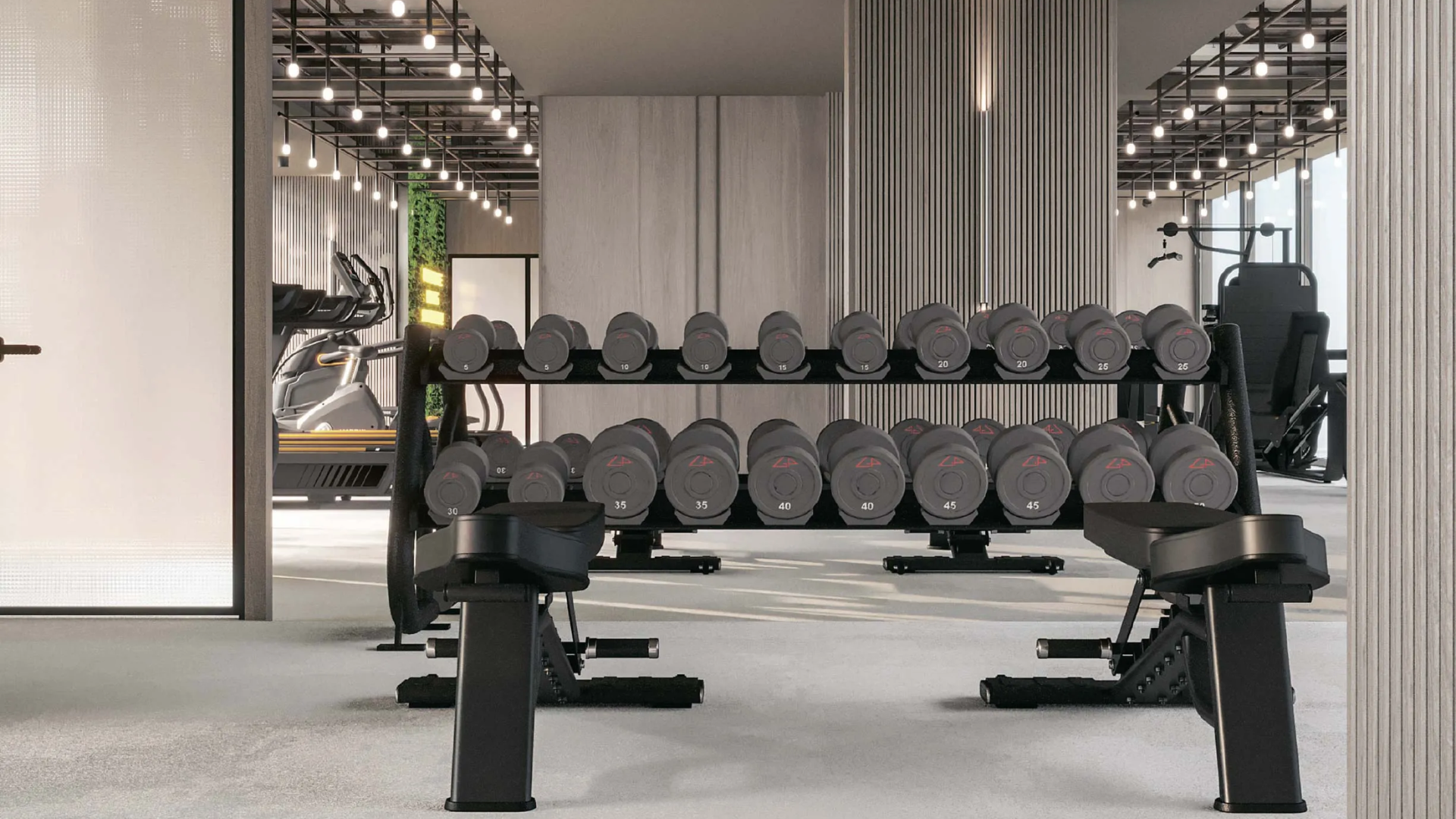 Well-equipped fitness center with treadmills, weights, and ample natural light.