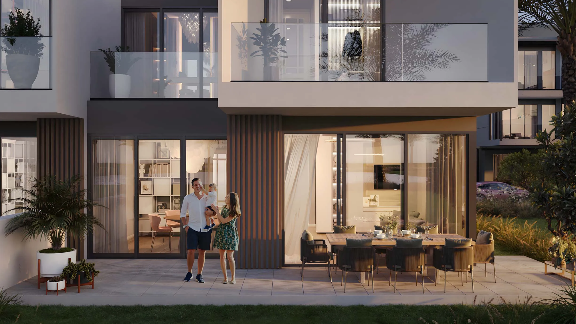Family enjoying patio area outside modern townhouse at dusk