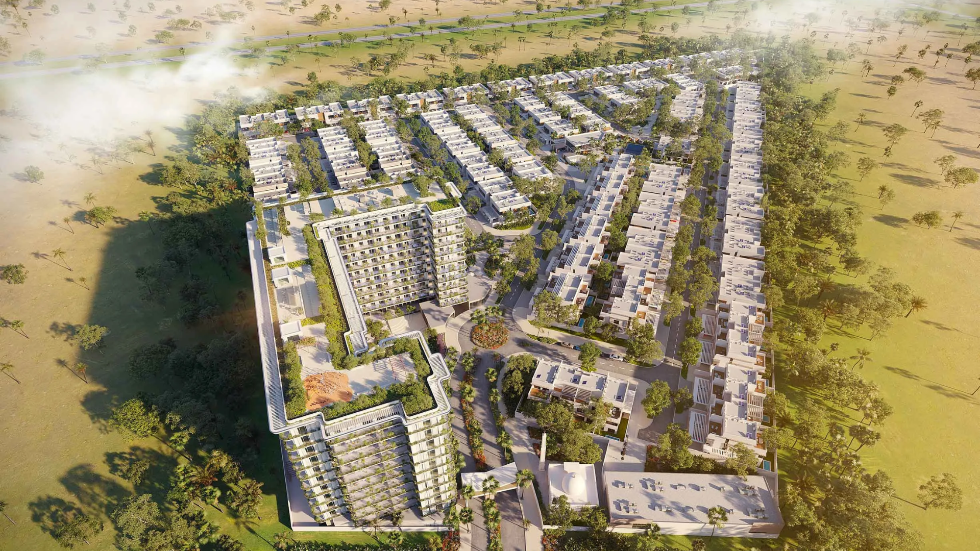 Aerial view of a large residential master community featuring low-rise villas and two modern apartment buildings surrounded by greenery.