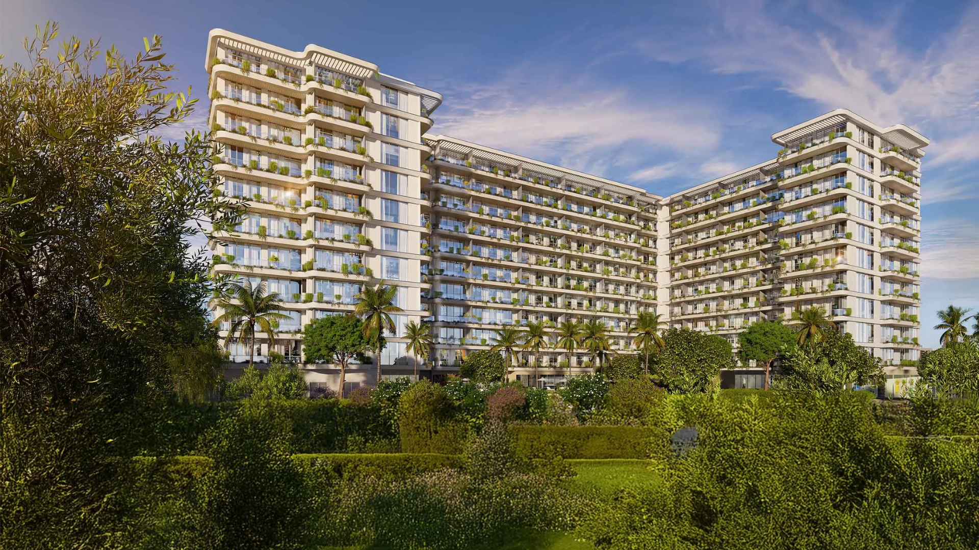 The modern exterior of California Residences, an apartment building in Dubailand surrounded by lush green landscaping.