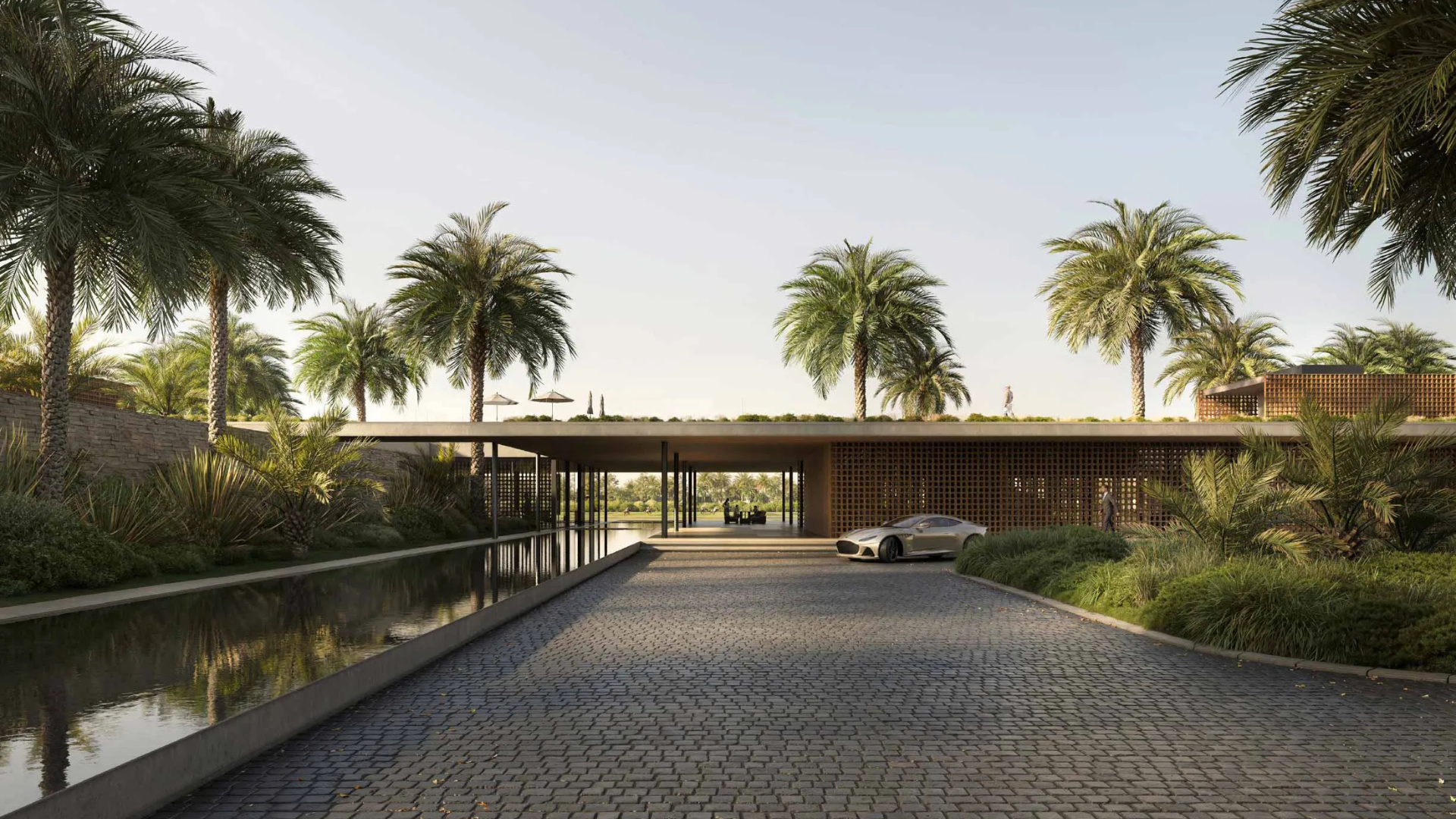 An elegant drop-off area with a modern canopy, cobblestone path, and a lush, landscaped environment.