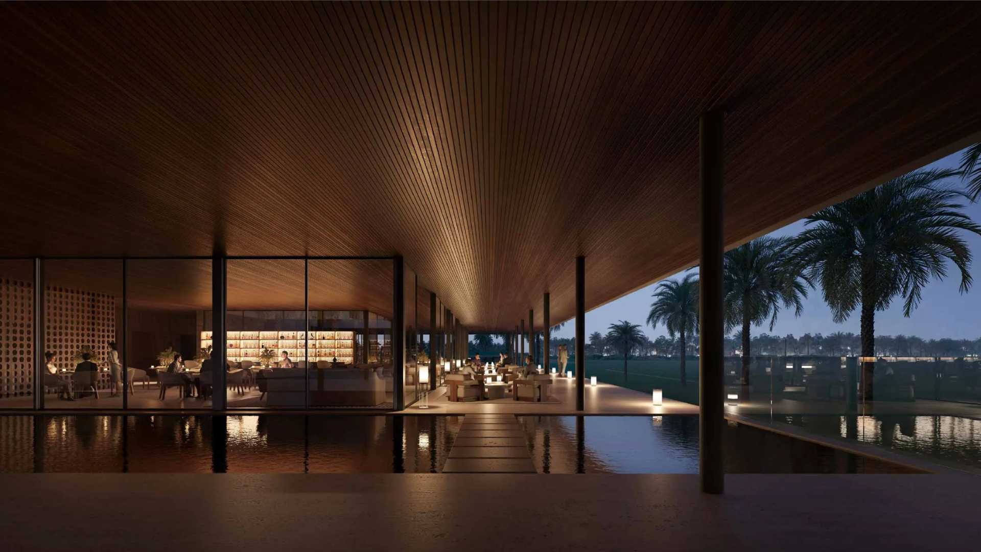 A modern outdoor lounge at dusk with a wooden ceiling, a bar, and seating areas next to a reflecting pool.