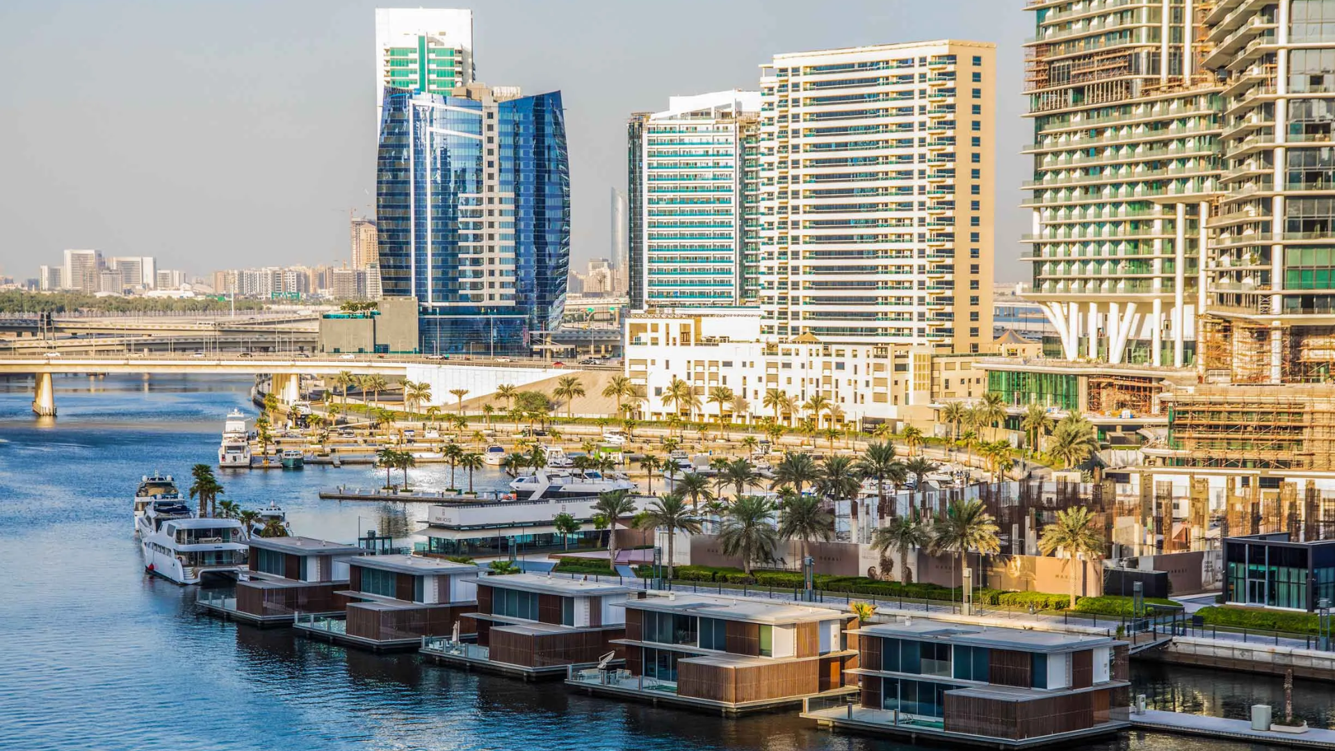 A bustling urban waterway with boats, residential buildings, and a mix of traditional and modern architecture.