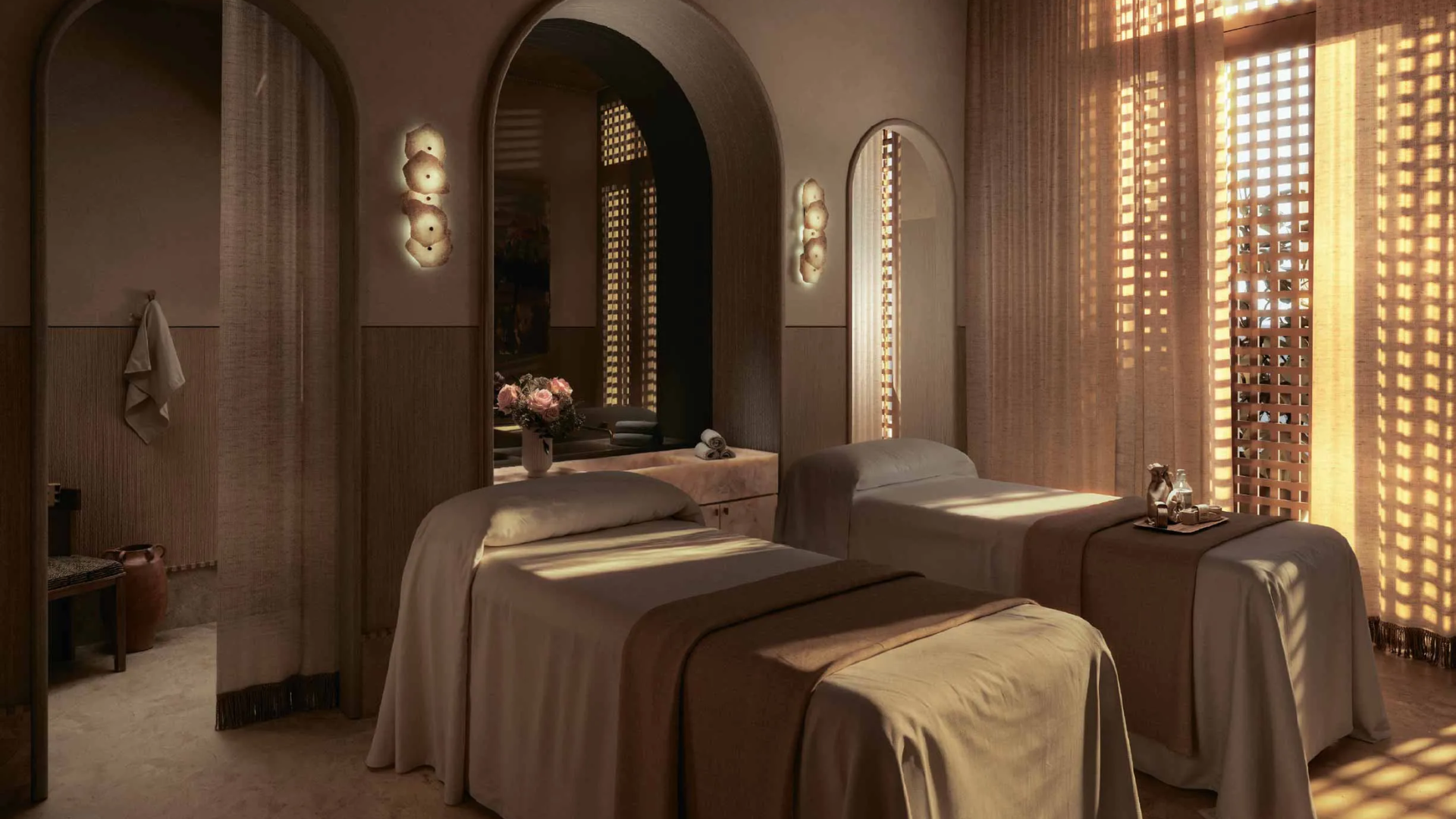Serene spa treatment room with two beds and soft, warm lighting, part of the wellness facilities.