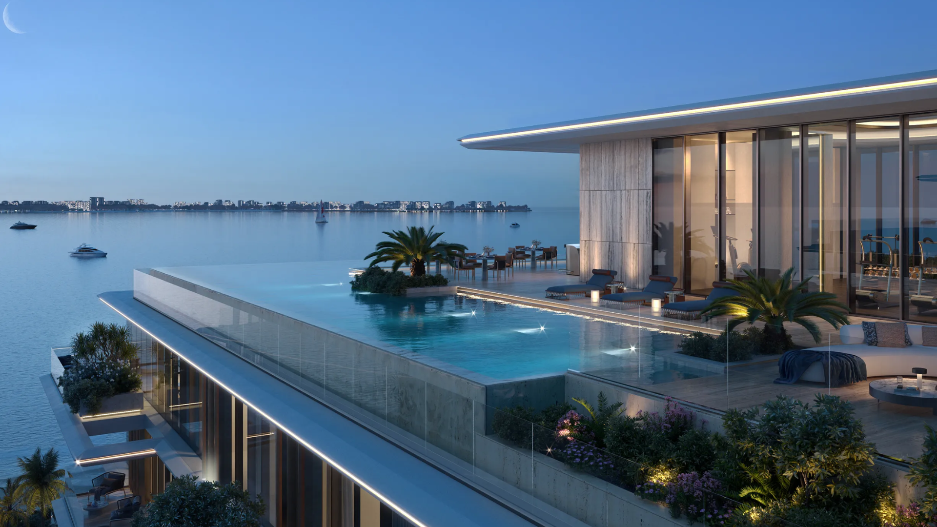 A stunning rooftop infinity pool overlooking a bay, with a lounge area and outdoor seating.