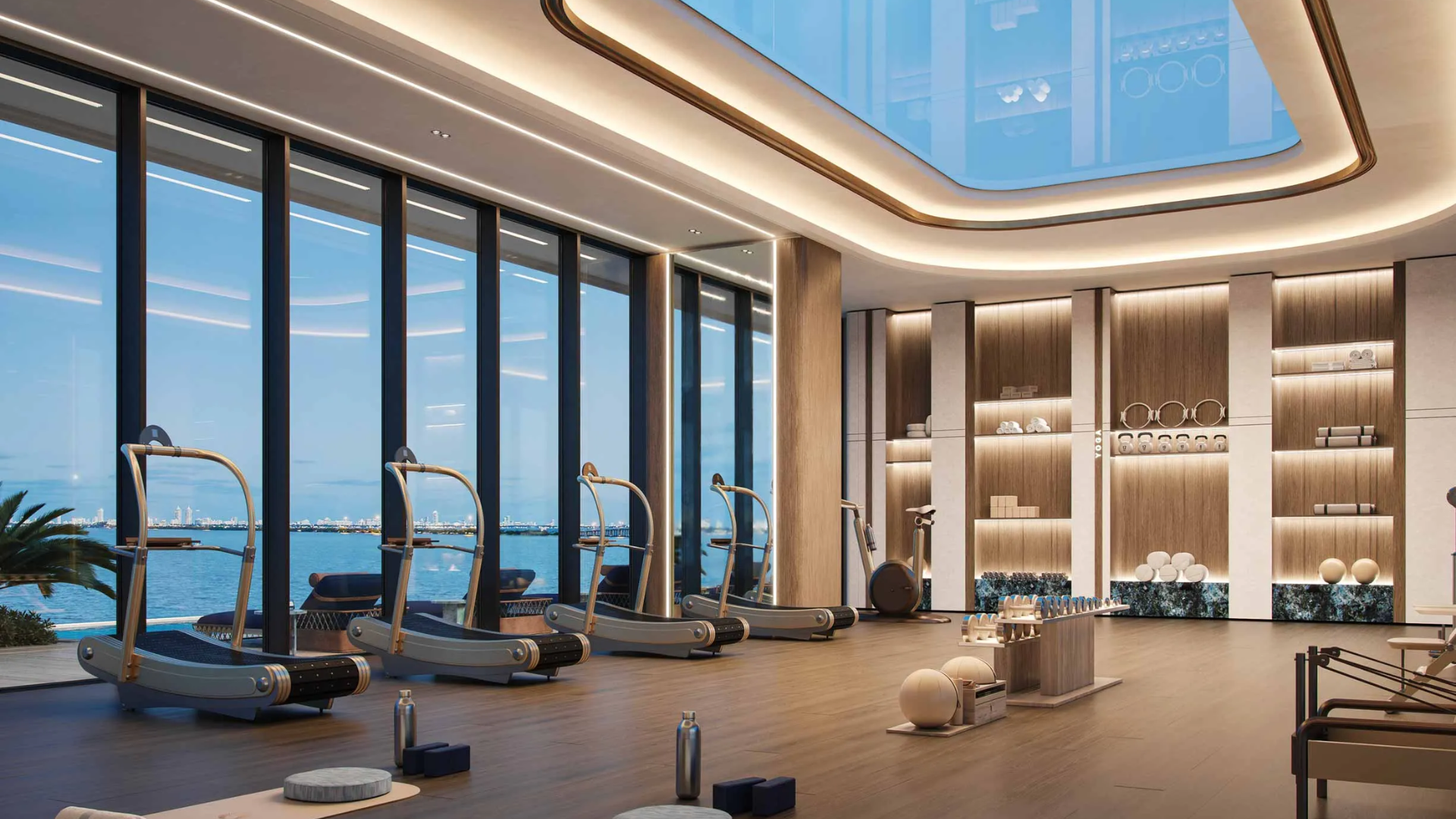 An elegant fitness center with a vaulted skylight, wooden floors, and ocean views.