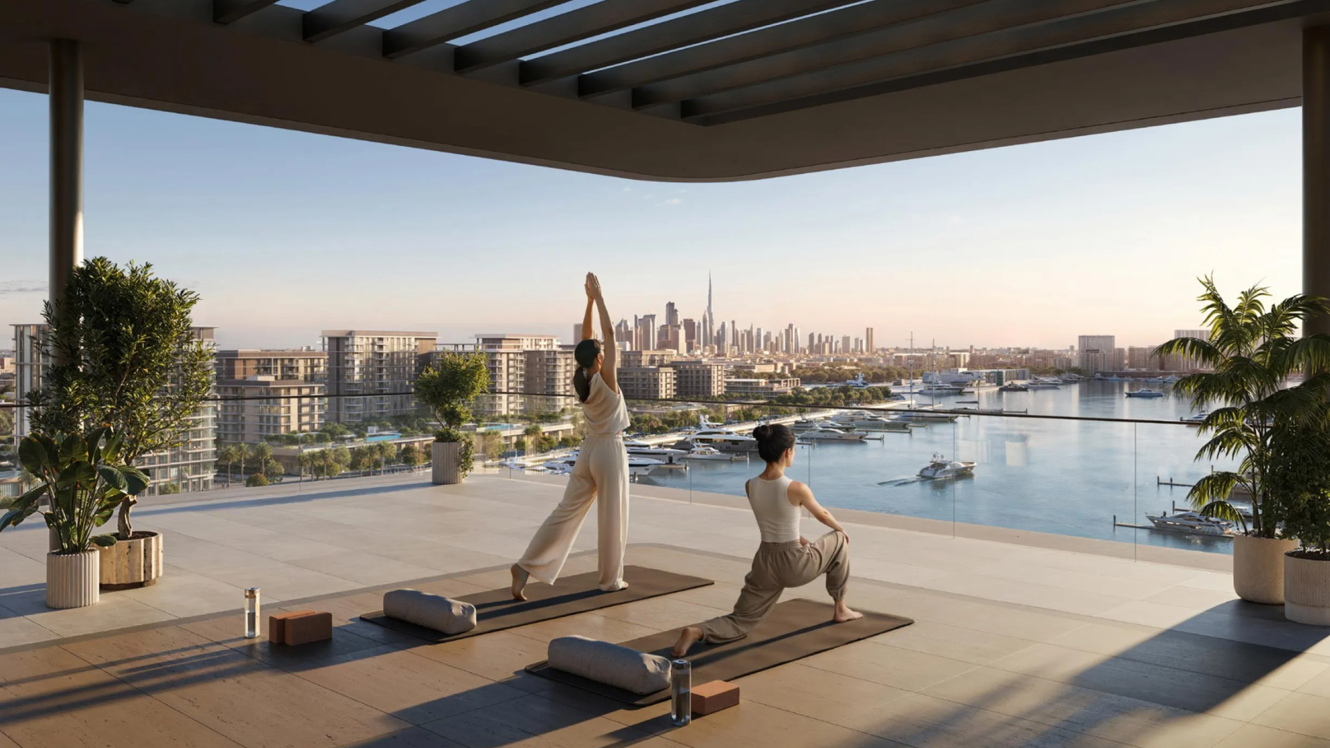 A wellness amenity at AUREA, showing residents practicing yoga on the terrace with a skyline view.