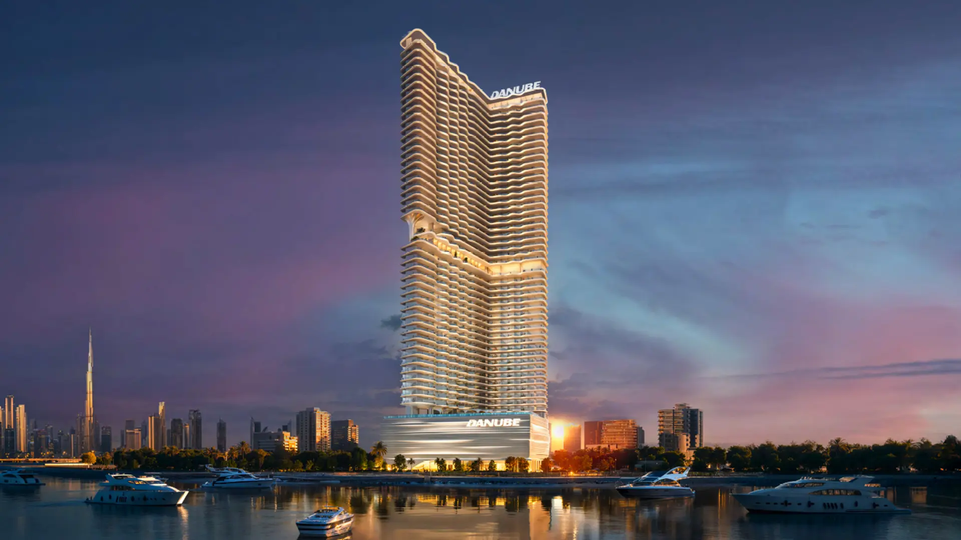 An evening view of the striking BREEZ residential skyscraper, designed with a distinctive curved facade.