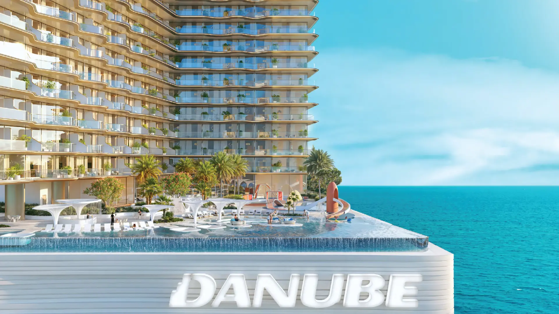 Waterfront buildings and leisure deck in Dubai Maritime City , featuring an outdoor pool with slides and tropical landscaping.