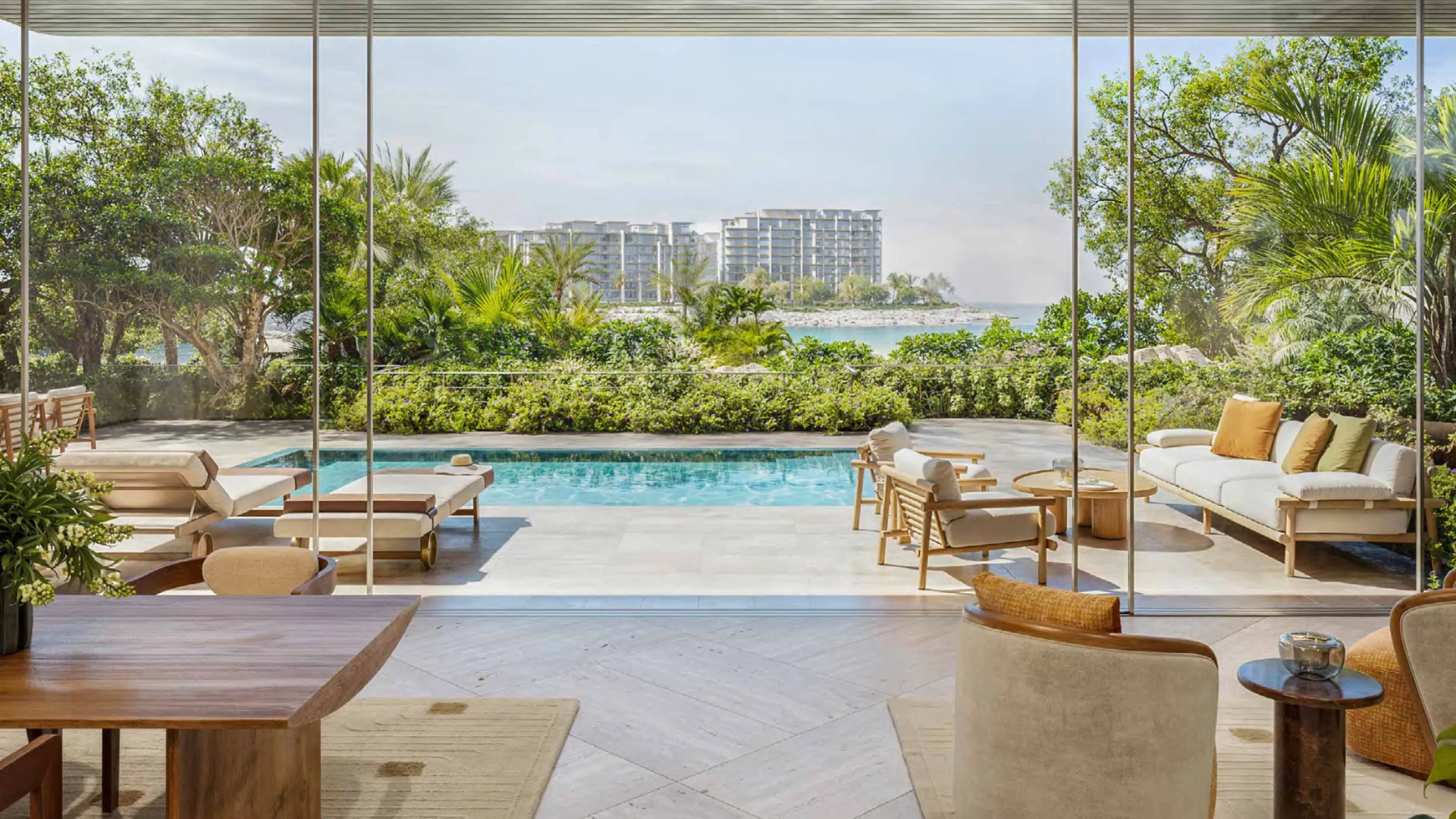 Contemporary apartment terrace with floor-to-ceiling glass doors opening onto a pool and sun loungers.