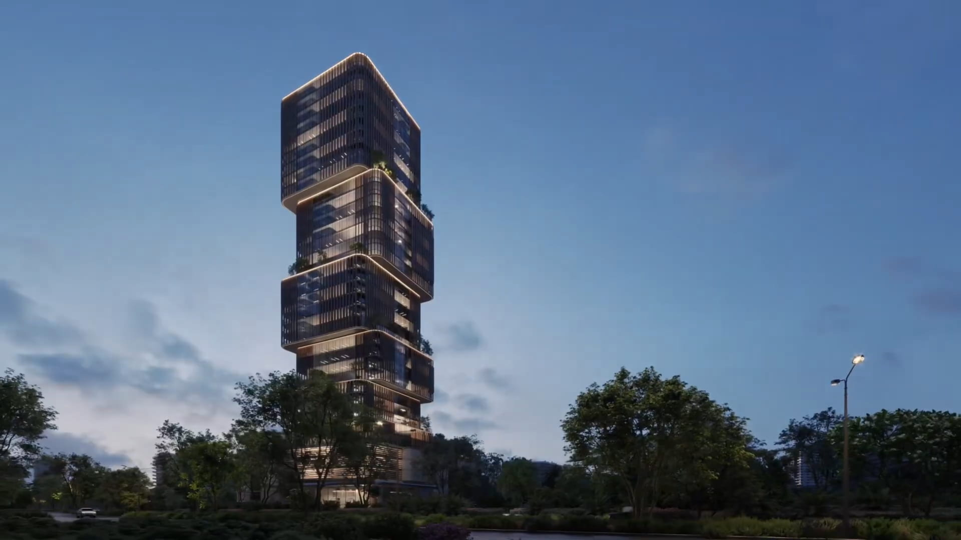 Modern high-rise building with a unique, stacked design and illuminated windows at dusk, surrounded by trees and greenery .