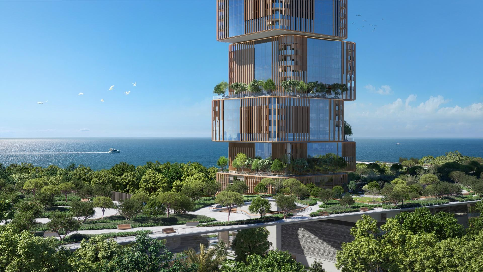 Waterfront commercial tower and surrounding park area in Dubai Maritime City.