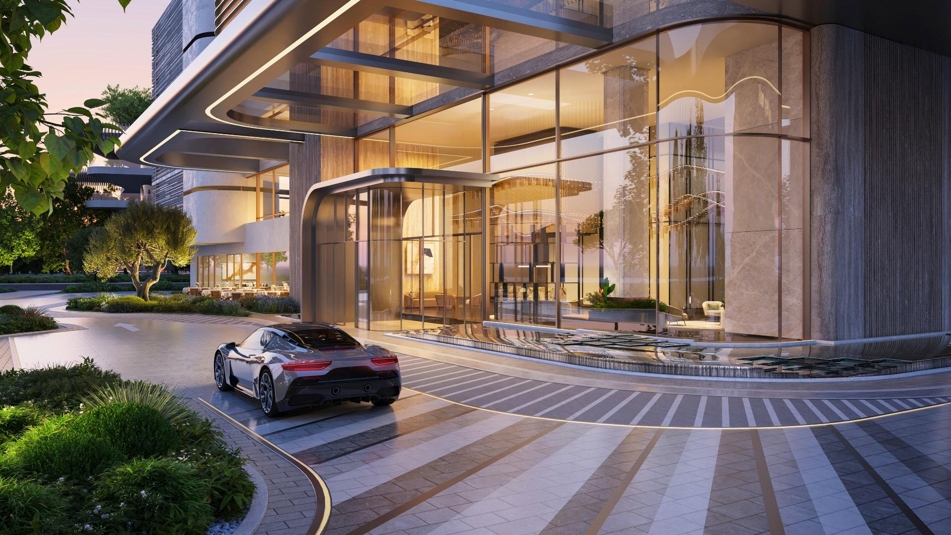 Architectural rendering of a grand building lobby entrance with reflective glass and a sleek driveway at sunset.