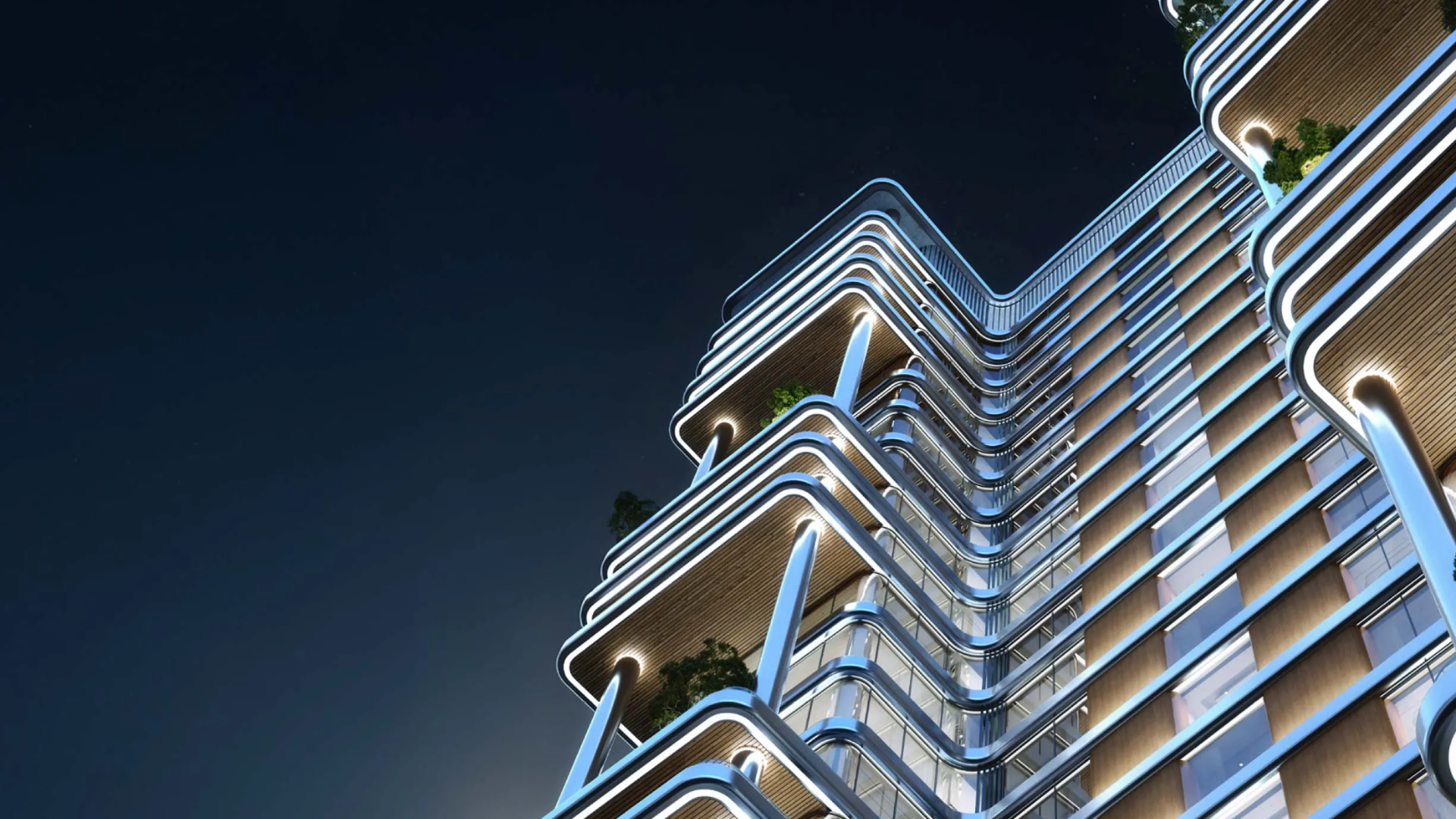 A close-up night view of a modern high-rise with curved balconies, sleek lighting, and glass façades.