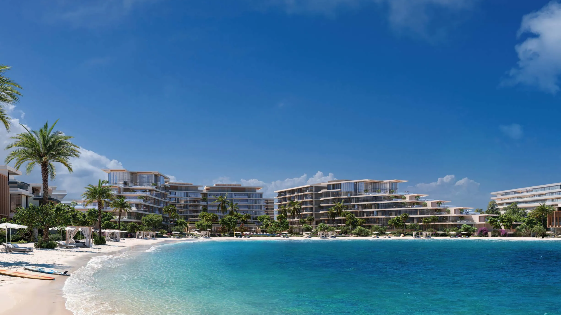 Beachfront residential buildings overlooking the clear blue waters of Palm Jebel Ali, surrounded by palm trees and white sandy shores.