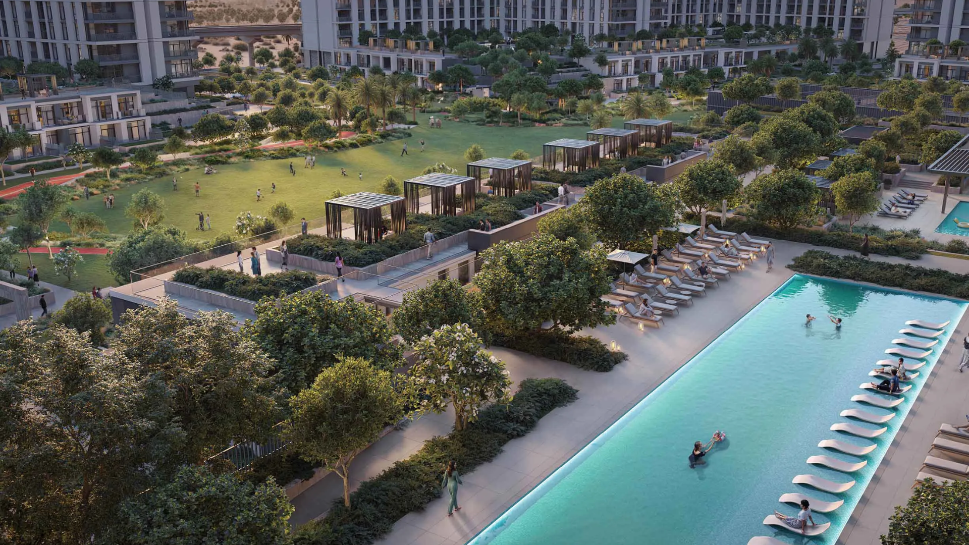 An aerial view of the long communal swimming pool and central park amenity area in the Dubai South community.