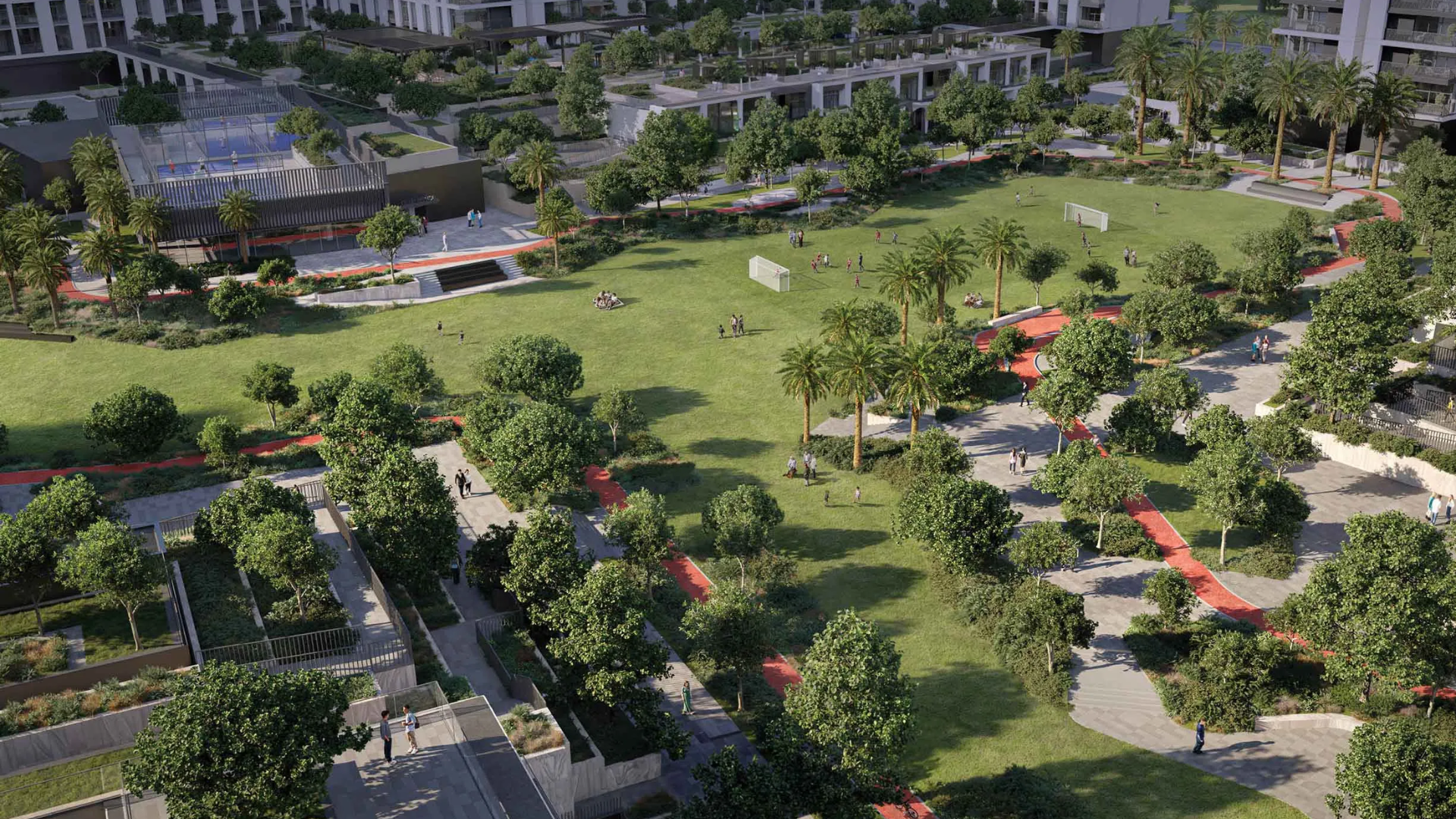 Aerial view of a large residential central park featuring walking paths, sports fields, and abundant green trees.