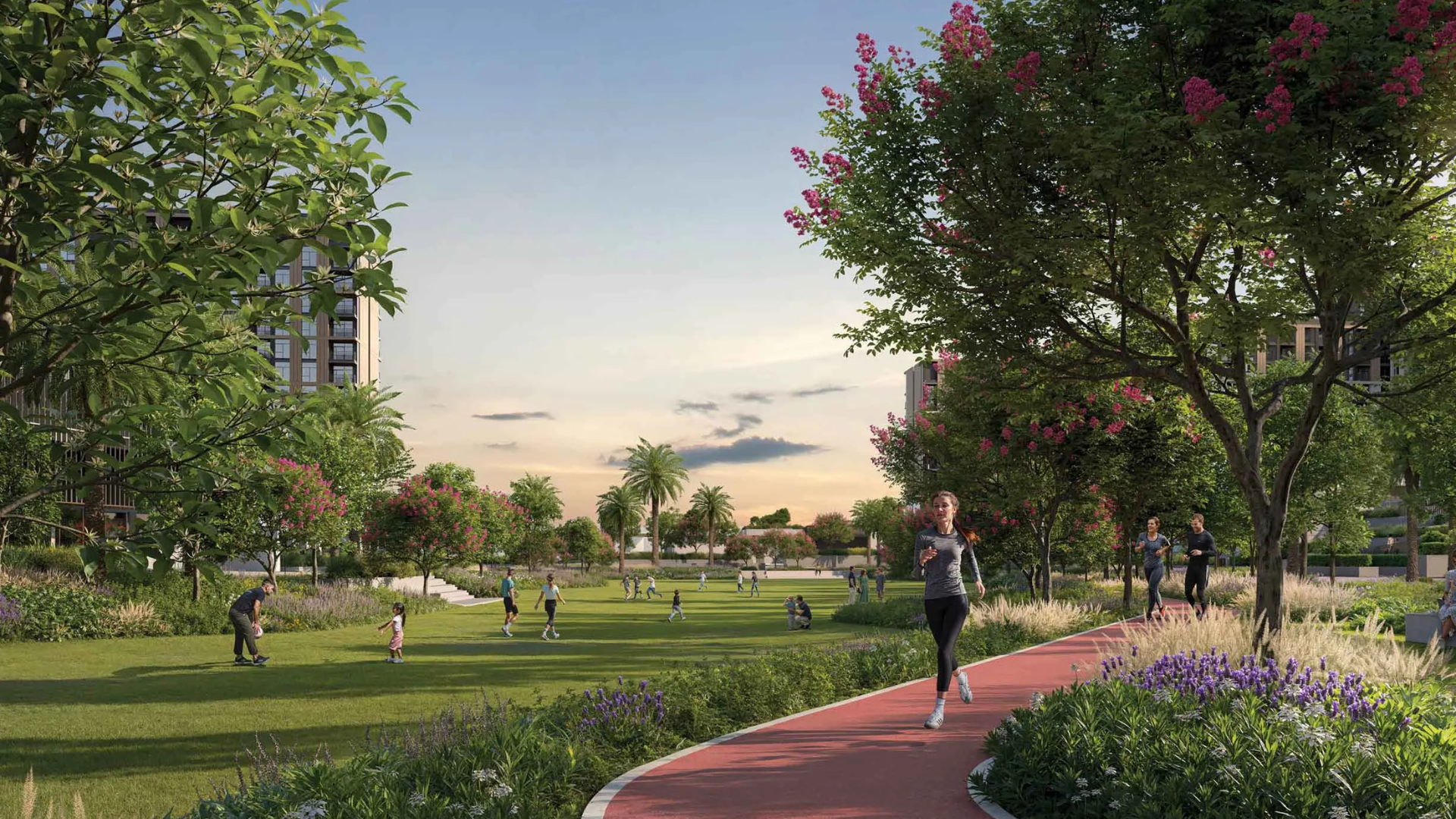 Lush community green space with flowering trees, a dedicated running path, and apartment buildings in the background.