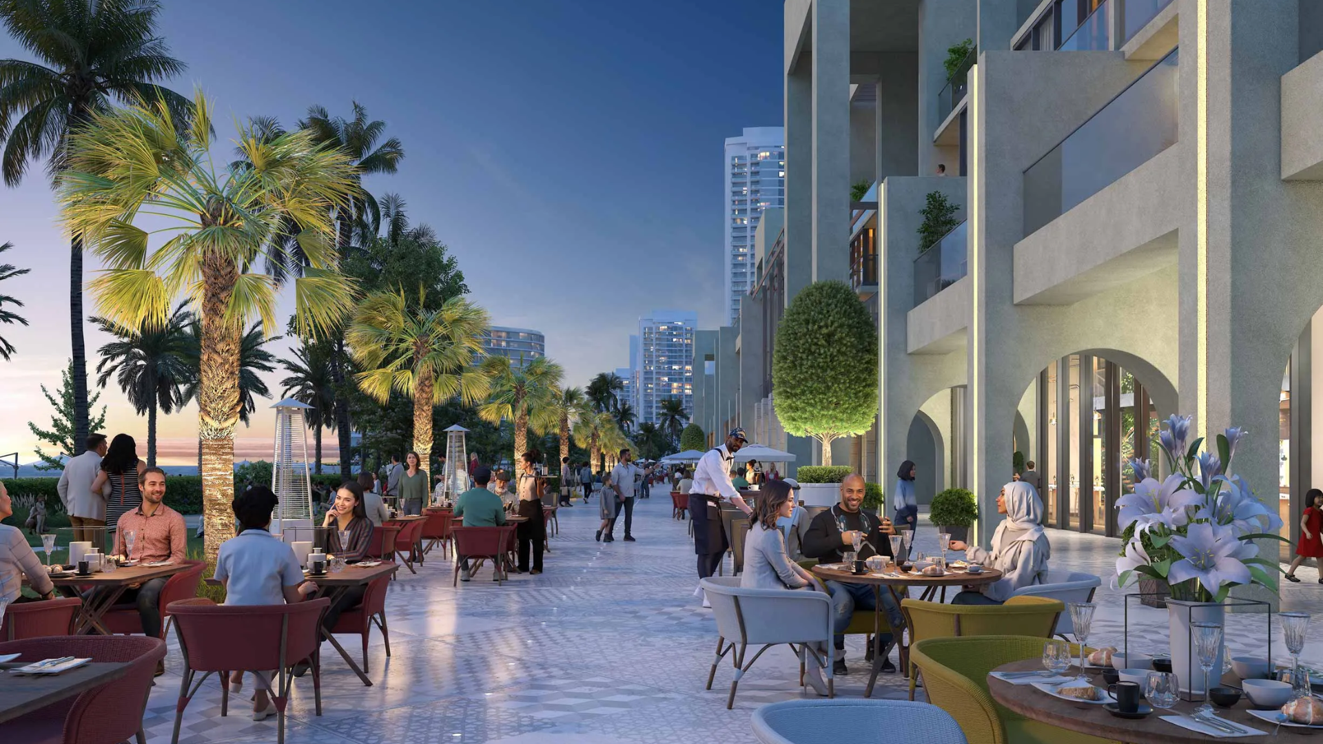 Outdoor dining promenade at a development by Sobha Realty, featuring people seated at tables and palm trees at dusk.