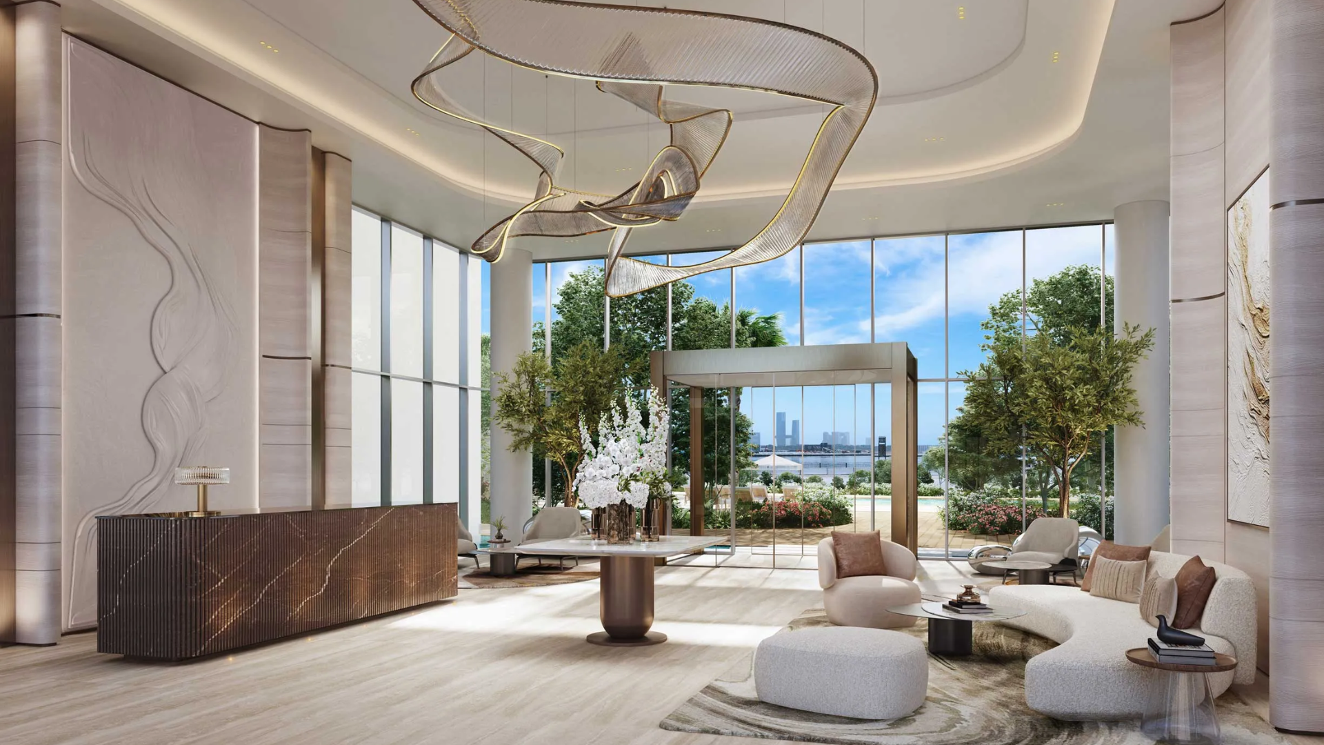 Grand residential lobby featuring an artistic, sculptural chandelier, a curved reception desk, and large windows with greenery.